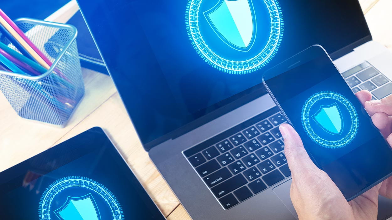 Businessman Using Smart phone to control  Cyber Security with laptop and tablet.